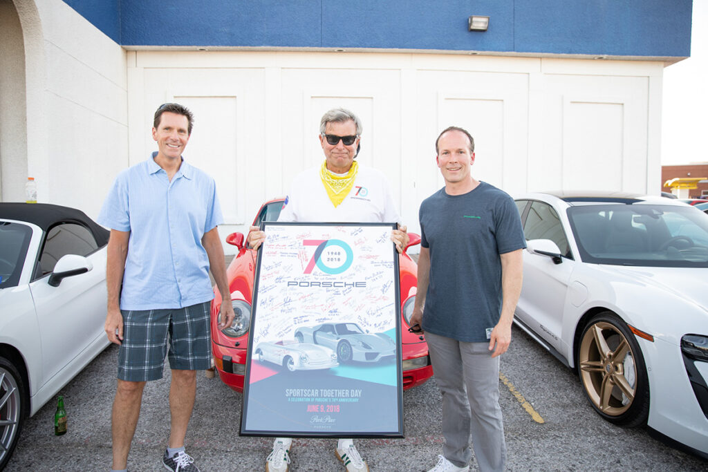 Porsche Cars North America Regional Manager Steve Krysil, Porsche Club of America – Maverick Region president Bill Kruder, and Park Place Porsche Dallas General Manager Patrick Huston at the June 8 celebration at Keller’s Drive-In on Northwest Highway in Dallas. Kruder (center) is holding a framed posted signed by each of the 2018 attendees at the 70th Porsche anniversary at Park Place Porsche Dallas on Lemmon Ave.